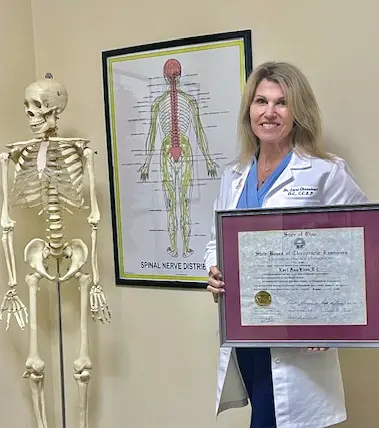 Dr. Lori Christian holding her sports physician certificate